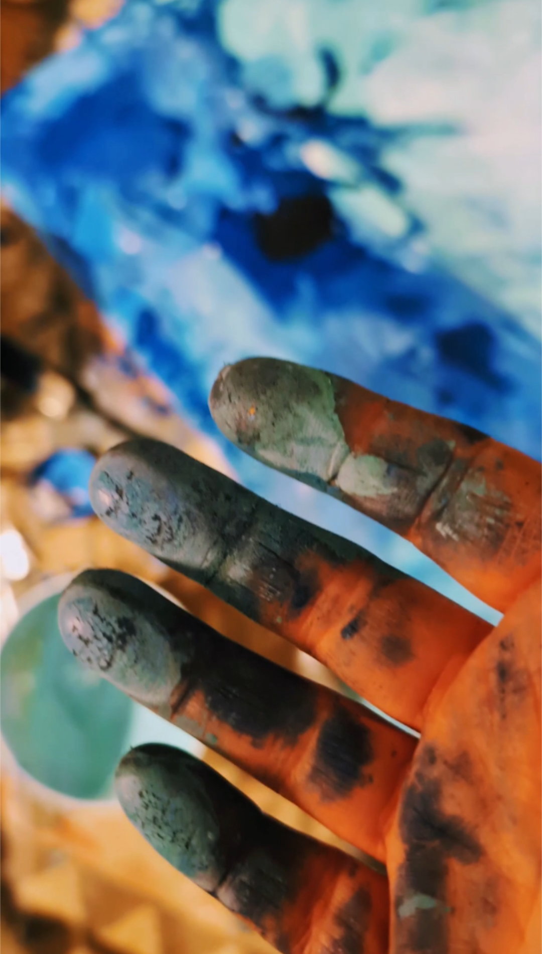 Artist at work — blue painting hands for mixed-media artwork
