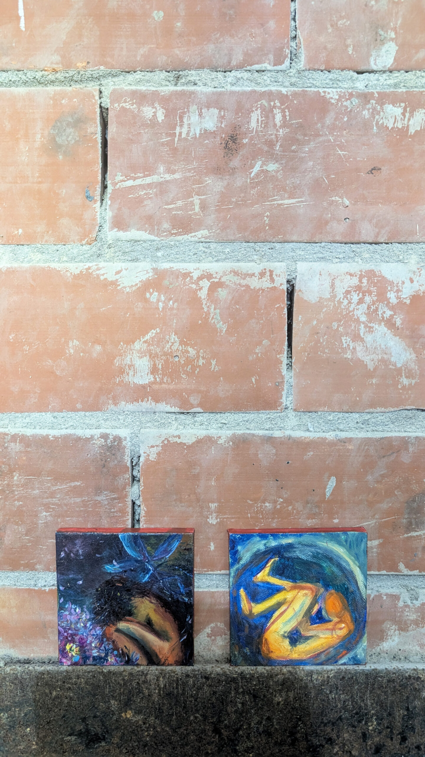Compact symbolic paintings presented against brick wall during Kunstschouw Zeeland exhibition by Leonoor Ruigrok