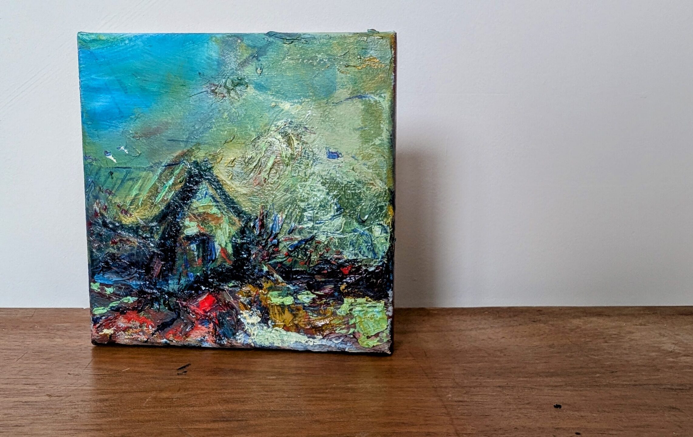 Small textured painting titled Shelter, with a dark house-like form in a turquoise, green and earthy abstract landscape.