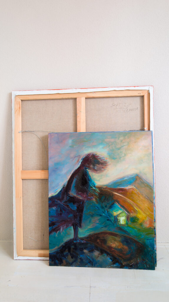 Expressive Dreamland painting with a dark figure and a small illuminated house, leaning against the back of a canvas in Leonoor Ruigrok’s studio.