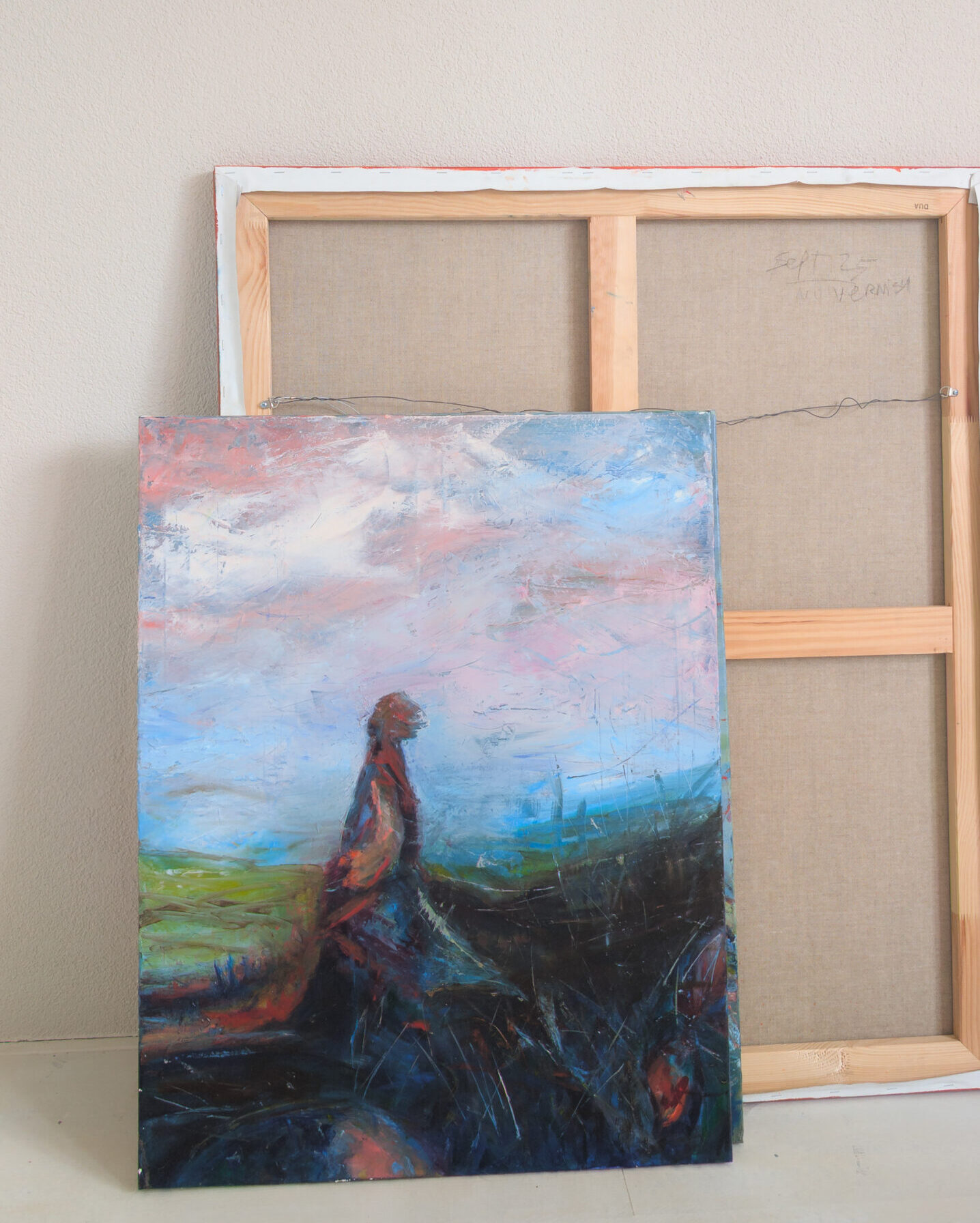 Dreamland art series painting by Leonoor Ruigrok, showing a dark walking figure in a layered blue, pink and black landscape in the studio.