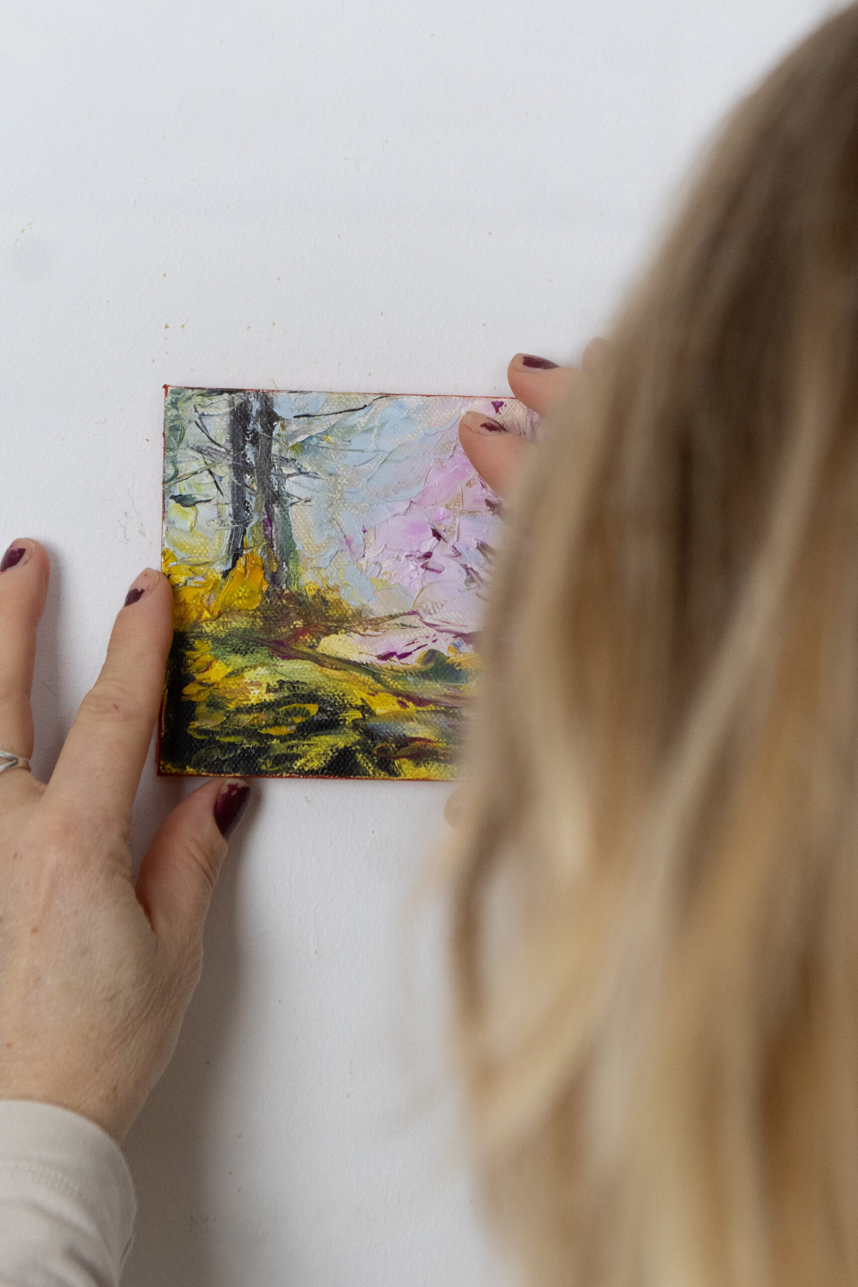 Leonoor Ruigrok hanging a very small original painting on a wall to show scale in an interior